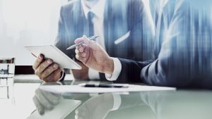 Corporate businessmen working on tablet at office - 